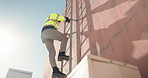 Outdoor, technician and man on ladder for rooftop installation, building or construction, Climb, back or low angle of cable contractor moving down on steps for electrical checkup or service on wall