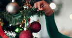 Hand, bauble or Christmas decoration by tree for holiday celebration, tradition or festive closeup. Glitter ball, ornament or Xmas event with person for creativity, aesthetic and bokeh with sparkle