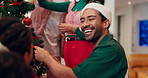 Christmas, decoration and tree with friends in home together for festive celebration or holiday. Bonding, ornament and smile with happy people at apartment for creative expression in December