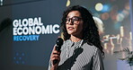 Speaker, woman and speech with mic at event for global economic recovery. Female person, public speaking and raise awareness for employment, business growth and solution with increase in job markets