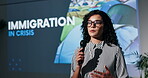 Business, woman and speech with mic at event for presentation on immigration crisis. Female presenter, public speaking and raise awareness, policy change and human rights violation and poverty issues