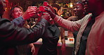 Excited people, night club and cheers with drink for party, celebration or toast together. Happy, group or friends with smile, alcohol or shots in late evening for good vibes, event or dance at bar