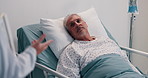 Mature man, doctor and patient with consultation on hospital bed for diagnoisis or treatment. Male person, lying and listening to medical professional for symptoms, side effects or results at clinic