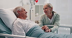 Talking, hospital bed and senior couple for comfort, support and empathy for recovery. Healthcare, marriage and mature woman visit man and holding hands for compassion, care and help for wellness