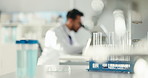 Glass vials, chemical and scientist with microscope in laboratory for pharmaceutical innovation. Test tubes, blurred and male biologist with DNA study for medical research, project or discovery.