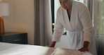 Chores, woman and making bed in home, bedroom or routine for maintenance of mattress, tidy or clean. Neat, morning and organizing pillows, housework and mature person with blanket in apartment
