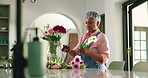 Arrangement, scissors and mature woman with flowers in vase for growth, natural bloom and plant care. Prune, home and person with bouquet, floral and blossom for display, decoration and aesthetic