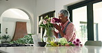 Arrangement, smell and woman with flowers in home for growth, natural bloom and plant care. Happy, aroma and person with bouquet, floral and blossom in vase for display, decoration and aesthetic