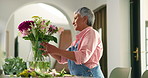 Arrangement, home and mature woman with flowers for present, birthday gift and celebration. Happy, house and person with bouquet, floral and bloom in vase for display, decoration and aesthetic