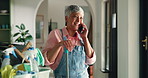 Phone call, spring cleaning and mature woman in home with appointment schedule for housekeeping. Cellphone, laughing and female cleaner on mobile conversation by products for chores in house.