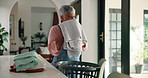 Mature woman, smell and packing laundry with basket for housekeeping, cleaning or chores at home. Female person, maid or cleaner with fabric fragrance for clothing hygiene or garment scent at house