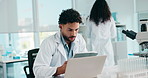 Medical research, scientist and man with tablet, lab and data analysis on website and biotechnology. Clinic, thinking and person with tech for project, reading and article of diseases on laptop