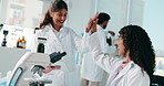 Scientist, women and high five with tablet, success or breakthrough for medical research project. People, partner and app with results, report or goal for vaccine development with pharma study at lab