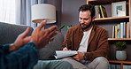 Man, therapist and writing with client on sofa for listening, advice or discussion at home. Male person, psychologist or counsellor taking notes for mental health, assessment or therapy session
