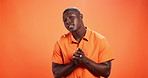 Face, black man and pride for fashion in studio background, trendy clothes and bold indie style. Portrait, mockup space and person with arms crossed for bohemian aesthetic, orange shirt and attitude 
