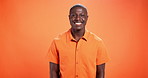Smile, happy and face of black man on orange background with pride, style and confidence. Aesthetic, mockup space and portrait of person with fashion, trendy clothes and cool outfit in studio