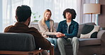 Office, therapist and talking to couple on sofa, counseling or discussion for pre marital therapy. Holding hands, man and woman with psychologist for communication skills, consultation and advice