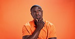 Memory, planning and thinking with black man on studio background for problem solving or solution. Future, ideas and wondering with African person on orange wall for contemplation or question