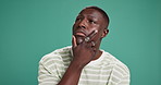 Confused, future and idea with black man on green background for problem solving or solution. Doubt, thinking and uncertain with African person in studio for brainstorming, contemplation or planning
