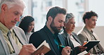 Businessman, writing and book in audience at convention with info, presentation or review at company. People, employee and thinking in crowd, event and attention with notes at corporate conference
