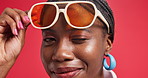 Black woman, sunglasses and wink in studio with smile, flirt and secret with fashion by background. African person, girl and happy with laugh for deal, trendy style and joke with closeup in Nigeria