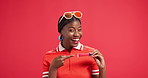 Face, pointing and black woman in studio with makeup for promotion, advertising space or announcement. Happy, smile and African female model showing mock up for product placement by red background