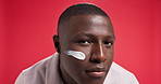 Cream, skincare and face of black man in studio for skin hydration, wellness and facial care. Dermatology, spa and portrait of person with moisturizer, lotion and creme for health on red background