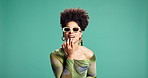 Woman, apply and lipgloss for fashion in studio for natural glow, cool clothes and makeover. African female person, sunglasses or cosmetics for lips shine, style and trendy outfit on green background