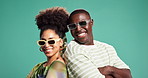 Face, smile and sunglasses with black couple on green background for bonding, fashion or love. Arms crossed, shades and style with happy people in studio together for energy, fun or wellness