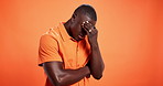 Stress, thinking and disappointed black man in studio overwhelmed by mistake or pressure. Regret, mockup space and frustrated male model isolated on orange background with rejection, anxiety or shame