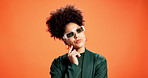Serious, thinking and woman with sunglasses, fashion and trendy accessory for influencer and studio. Orange background, contemplating and African person with shades, mockup space and colorful jacket