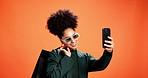 Studio, selfie and woman with shopping bags, smile and stylish with discount for clothes and memory. Orange background, influencer and African person with products for fashion, happy and photography