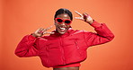 Happy, black woman and face with peace sign in fashion for style on a orange studio background. Portrait, female person or African model with smile, emoji or peace sign in stylish outfit on space