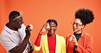 Skincare, product and promotion with friends in studio for beauty, cosmetologist and glow. Cosmetics, dermatology and hydration with people on orange background for aesthetic and facial treatment