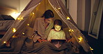 Tablet, tent and mother with child at night for streaming movie, film or series together for bonding. Relax, blanket fort and mom with kid on digital technology for playing educational game in home.