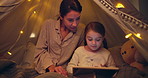Tablet, tent and mom with kid at night for streaming movie, film or series together for bonding. Relax, blanket fort and mother with child on digital technology for playing educational game in home.