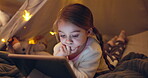 Child, relax and tablet in tent at house for streaming movies, watching cartoon and bedtime routine. Child, night and digital app for surfing internet, multimedia and reading ebook for entertainment