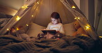 Storytelling, tablet and scroll with child in bedroom for bedtime story, reading and online. Fantasy, night and fairytale with kid in blanket fort in family home for learning, relax and study