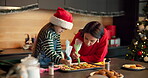 Child, mother and piping cooking for Christmas decoration, icing skills and sweet treats in kitchen. Kid, woman and help with baking, festive preparation and Santa snacks by bonding together at house