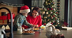 Kid, mom and piping cooking for Christmas decoration, icing skills and sweet treats in kitchen. Child, woman and helping with baking, festive preparation and Santa snacks by bonding together at house