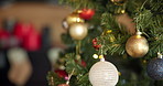 Christmas, tree and ornaments in home for decoration for holiday tradition, vacation and festive season. December, closeup and shiny baubles, balls and lights for celebration, event and xmas party