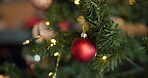 Christmas, ball and bauble with decoration on tree for sparkle, festive or holiday season. Merry xmas, tradition and December celebration with ornament in living room of home for vacation and closeup