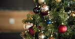 Christmas, festive and bauble with decoration on tree for sparkle, ball or holiday season. Merry xmas, tradition and December celebration with ornament in living room of home for vacation and closeup