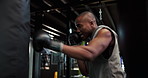 Boxer, punching bag and workout with black man in gym for combat sports, fight or training. Exercise, fitness and technique with boxing athlete in health club for conditioning, skill or strength