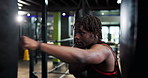 Boxing, fitness and black man in gym for workout, cardio or training for MMA fight with challenge. Strong, exercise and African male athlete with power punching for self defense at sports center.