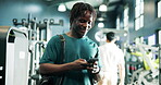 Fitness, man and phone with texting in gym for workout tracking, chat notification or training app. Athlete, person and sports bag with smartphone at health club for exercise progress or reading info