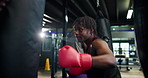 Boxing, punching bag and training with black man in gym for combat sports, fight or workout. Exercise, fitness and technique with athletic boxer in health club for conditioning, skill or strength
