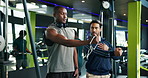 Man, fitness coach or weightlifting with cable machine for arm exercise or workout at gym. Male people, instructor and helping bodybuilder with training technique tips for muscle gain at health club