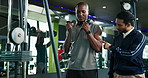 Men, fitness coach or weightlifting with cable pulley machine for arm exercise or workout at gym. Male people, instructor or helping customer with training technique, triceps or tips at health club