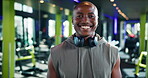 Face, fitness and headphones with black man in gym for training or workout as professional athlete. Exercise, smile and wellness with happy person in health club for development or sports performance